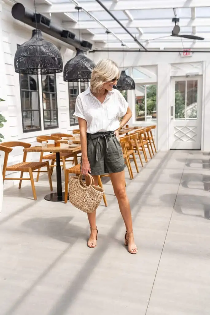 olive green paper bag shorts from JCpenney styled with white stripe short sleeve button down and straw handbag for summer