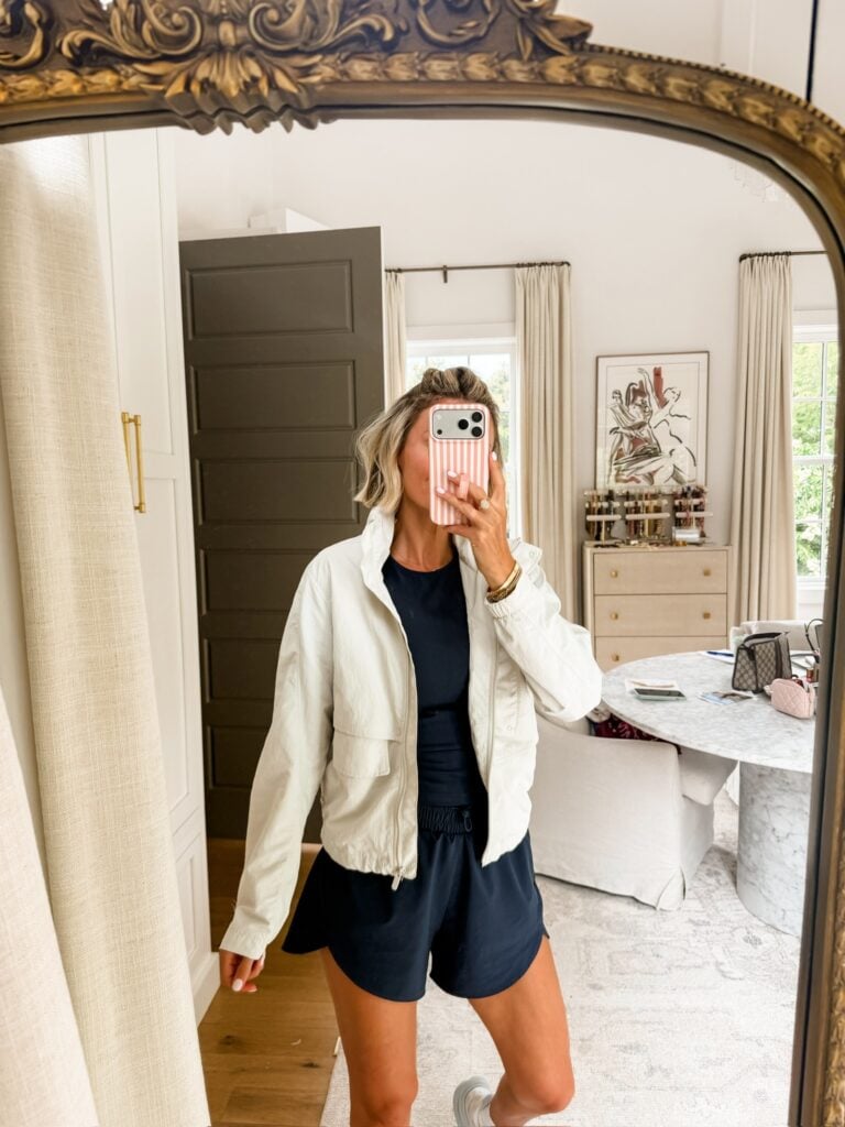 Black active outfit with cream jacket layered on top.